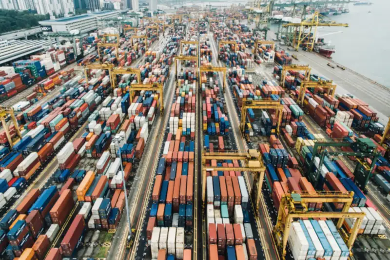 Aerial view of a busy container port with rows of stacked containers